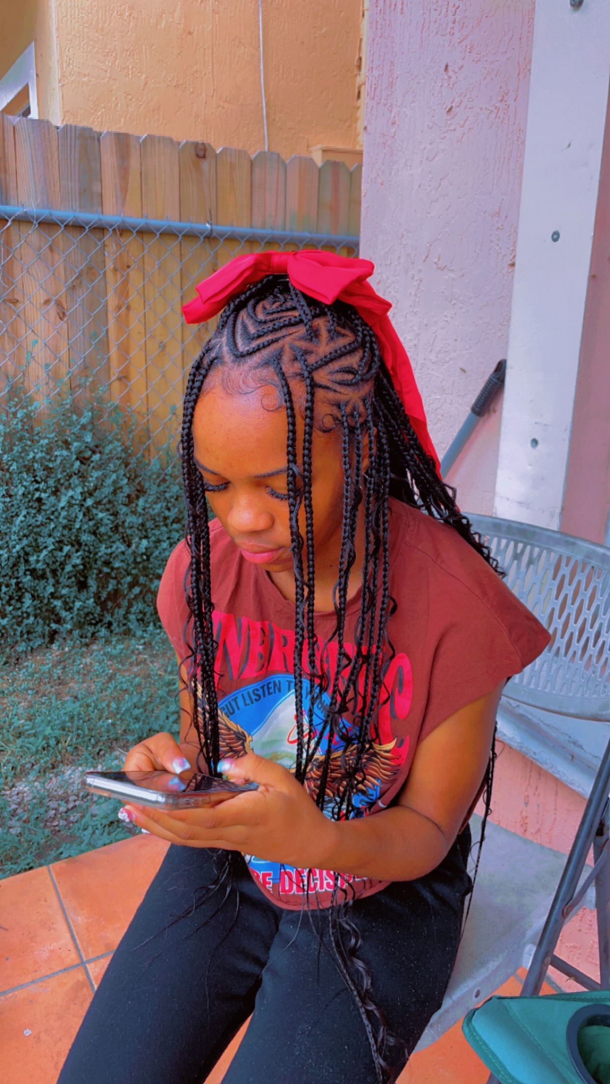 Long feed-in braids with a red bow