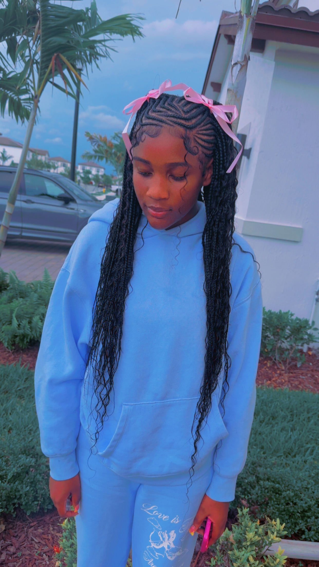 Long creative braids with pink ribbon accents